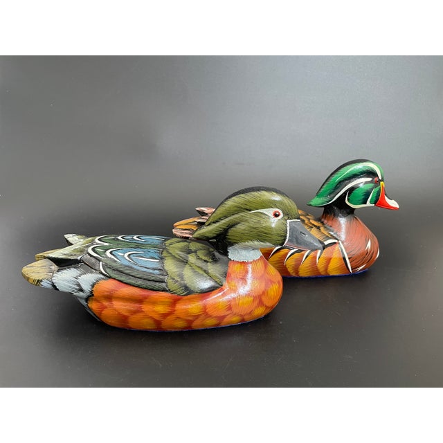 A vintage pair of Wood Duck artisan decoys, consisting of a drake and a hen. Hand carved and hand painted with bold hues...