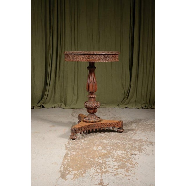 A characterful and finely carved Anglo Indian rosewood circular tilt topped centre table, having a highly figured one...