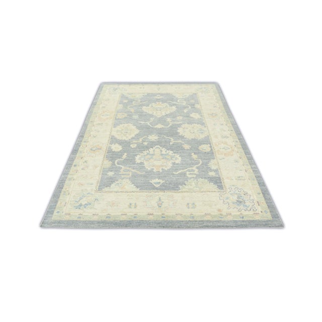 This modern Turkish Oushak rug is a stunning piece of art that has been handwoven using traditional techniques by skilled...