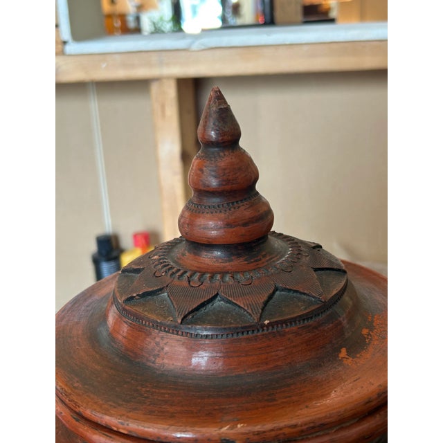 Vintage lidded, terra-cotta urn with faux wood finish.