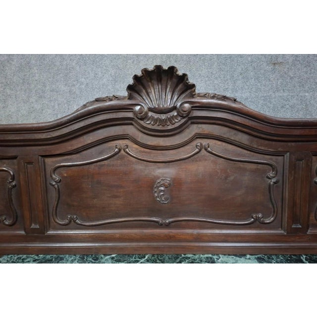 Elegant carved wooden bed headboard, a 19th-century French piece in the Louis XV style. with its flowing lines, it...