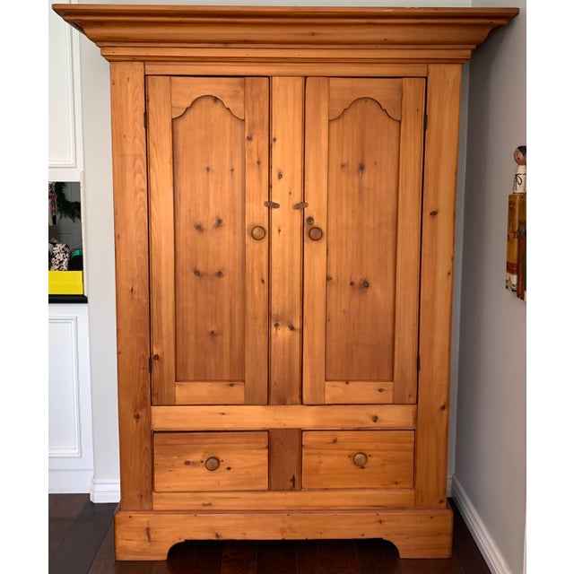Mid 18 century French Canadian pine cupboard from the province of Quebec. Top pediment done with the decoration of a Jean...