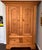 Mid 18 century French Canadian pine cupboard from the province of Quebec. Top pediment done with the decoration of a Jean...
