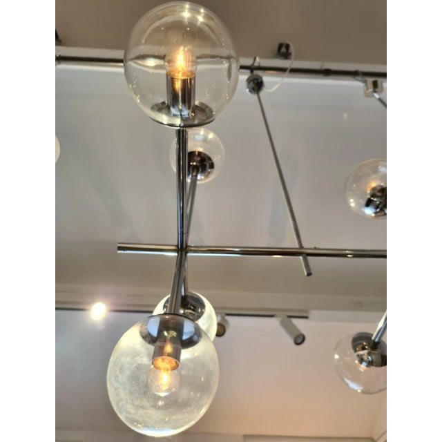 Large chrome hanging lamp with 12 glass globes. This piece has an attribution mark, I am sure that it is completely...