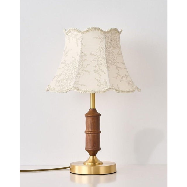Shade is beige patterned fabric (with lace trim + subtle pattern), body is solid wood with copper hardware, built-in...