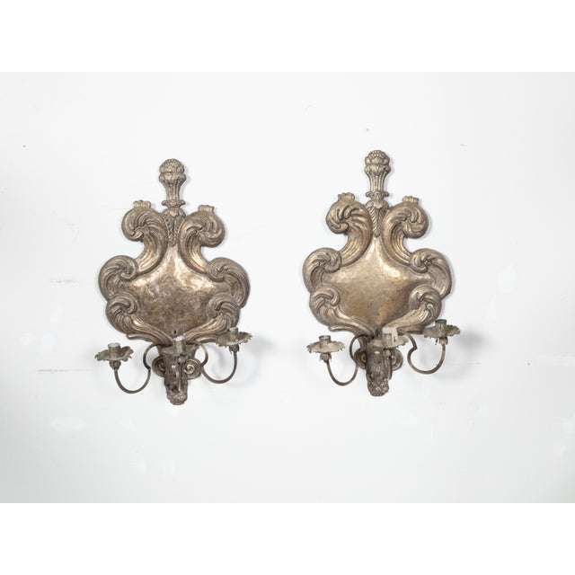 A pair of Italian Rococo style tin candle sconces from the 19th century, with three arms and feather motifs. Created in...
