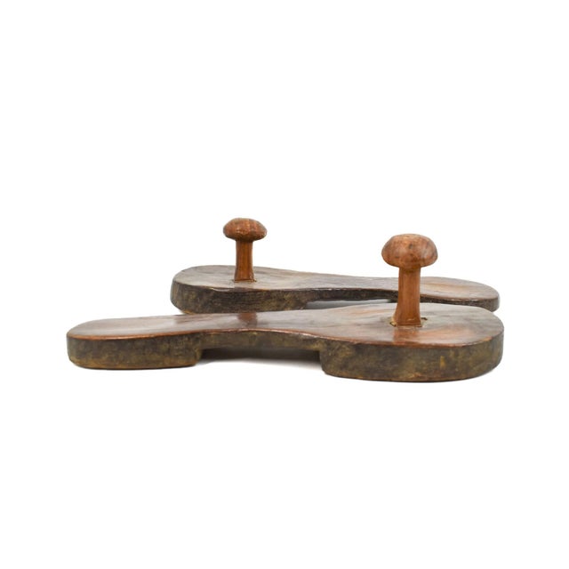 Dogon wooden shoes are traditional footwear crafted by the Dogon people, an ethnic group from the central plateau of Mali...
