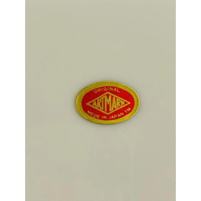 Imari style decorative bowl with predominantly blue and white center and border in orange and blue. All outlined in gold....