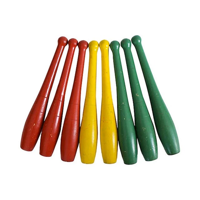 Set of eight wood vintage carnival game pins in original red, green, and yellow paint. Surface wear from use, chips, and...