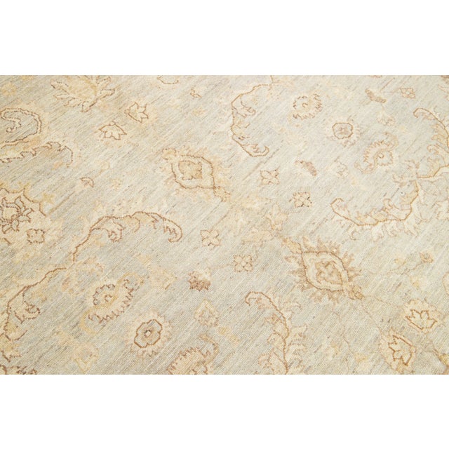 This contemporary handmade Peshawar wool rug features a gray background with elegant beige highlights. It boasts a...