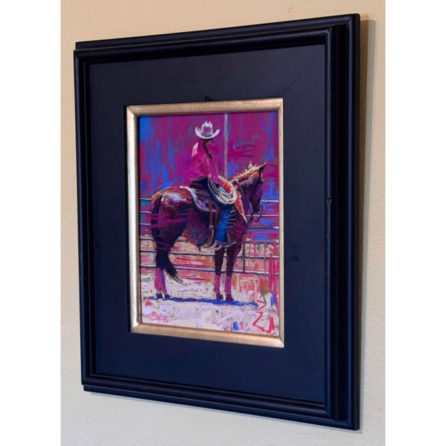 This artwork captures a moment in a vibrant rodeo scene, where a rider in a pink shirt sits atop a horse, exuding a sense...