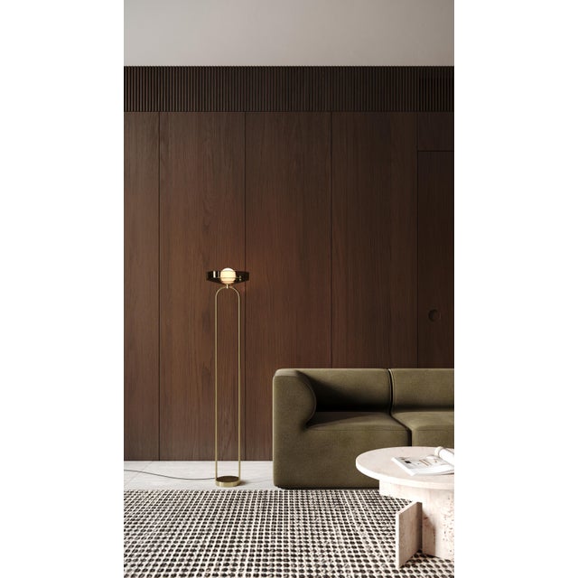 Floor Lamp. The floor lamp is a sculptural object, crafted from hand-blown glass and elegantly curved brass, casting a...