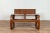 An antique Indonesian teak wood settee from the early 20th century, with cane two-seater and looping arms. Found in...