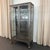 This monumental antique industrial apothecary vitrine cabinet seamlessly bridges the gap between historical utilitarianism...