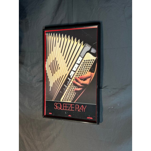 Framed vintage-style poster titled “Squeeze Play” featuring a bold close-up graphic of an accordion being played by a hand...