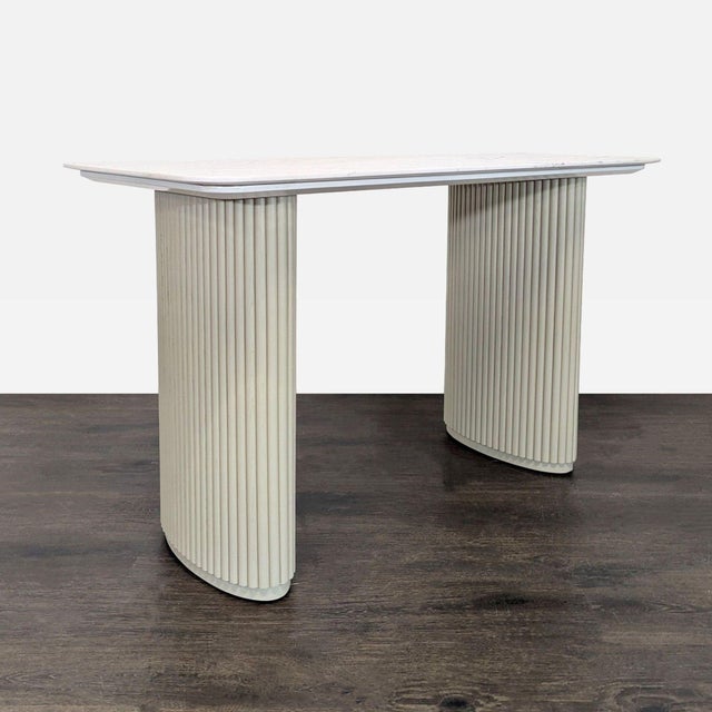 This elegant desk from Rove Concepts features a sleek white marble top and sturdy cream-colored fluted legs. The...