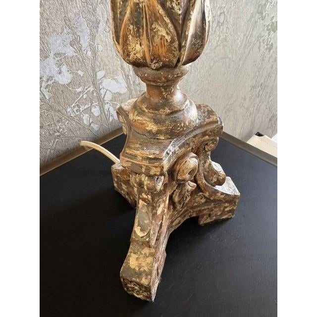 French Provincial / Louis XV–style wood base table lamp. Distressed finish. The tapered drum shade is in beige linen. Lamp...