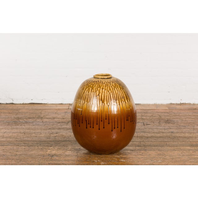 A Prem Collection ceramic artisan handcrafted two toned vase with brown, yellow and orange glaze and dripping motifs....