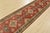 A tribal Kazak runner hand-knotted with fine wool on a cotton foundation. This oriental rug features a row of medallions...