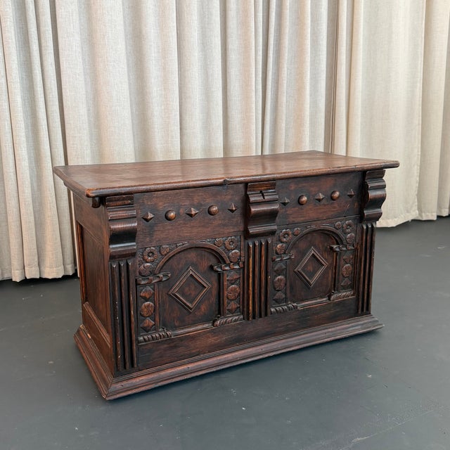 This antique, 19th century, artisan-made blanket chest trunk features an ornately hand-carved dark mahogany façade adorned...