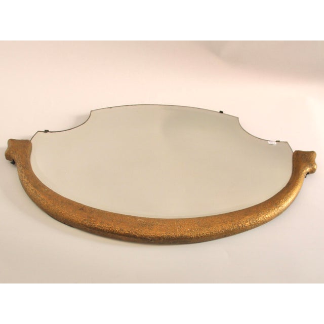This golden French Art Deco mirror with ornaments was produced in the 1930s. All parts original, mirror and frame show...