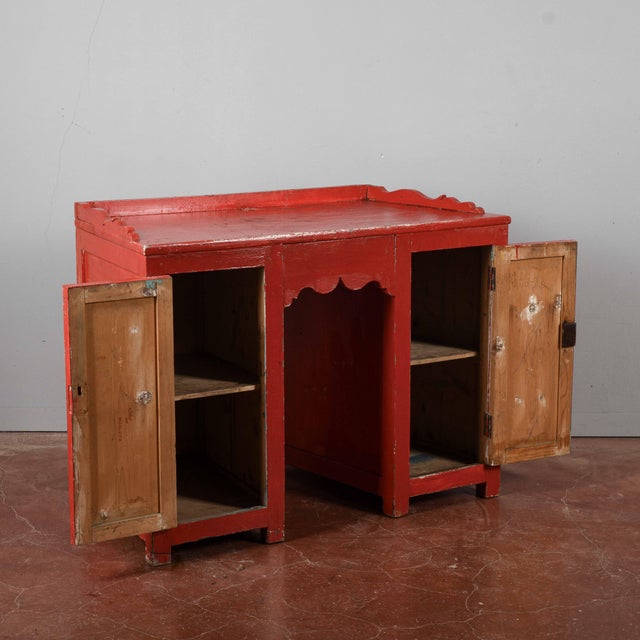 This small vintage desk/dressing table, with its vibrant red finish and signs of age, is a unique piece that offers the...