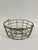 This antique wire basket, dating to the early–mid 20th century, was traditionally used on farms for collecting and...