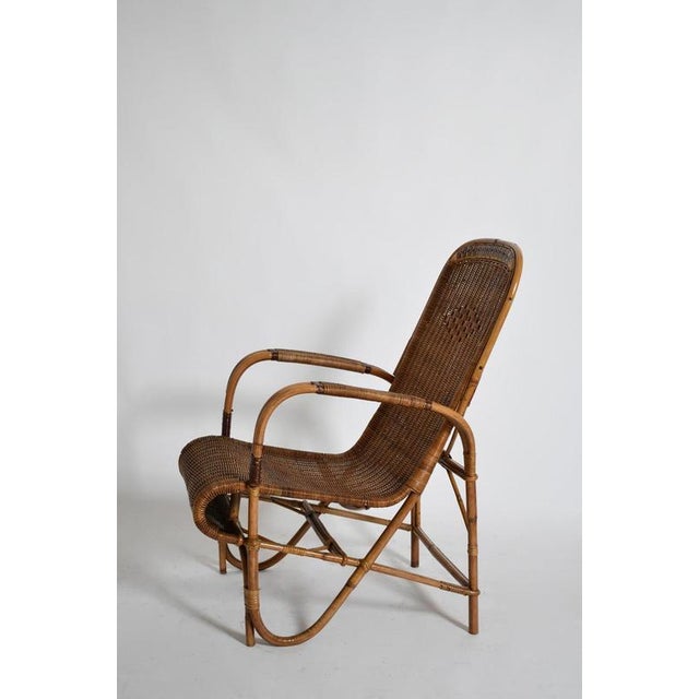 Rattan and wicker high back armchair, 1950s. Height: 96 cm - 37.8 in Length: 59 cm - 23.23 in Width: 70 cm - 27.56 in...