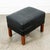 Danish modern black leather ottoman / footstool with wood legs. Unknown maker. Recently imported from Denmark.