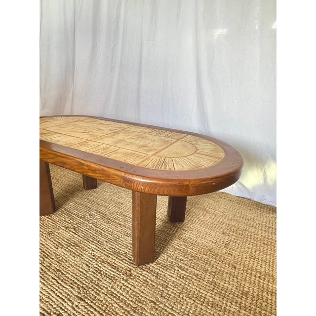 Coffee table from the 1960s/70s. Oval top adorned with ceramic tiles featuring an incised wheat stalk motif, in the style...