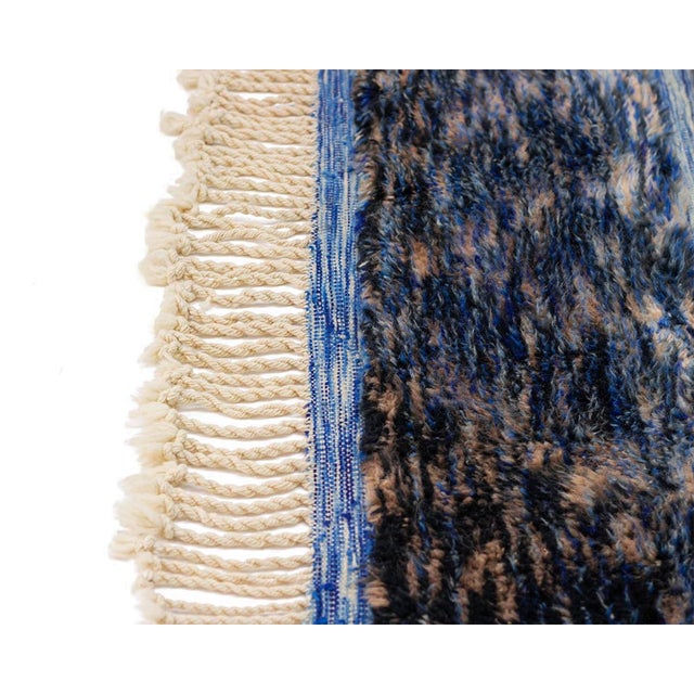 A rug of quiet contrast — where deep, textured charcoal dissolves into a crisp diamond lattice of ocean and sky blue. The...