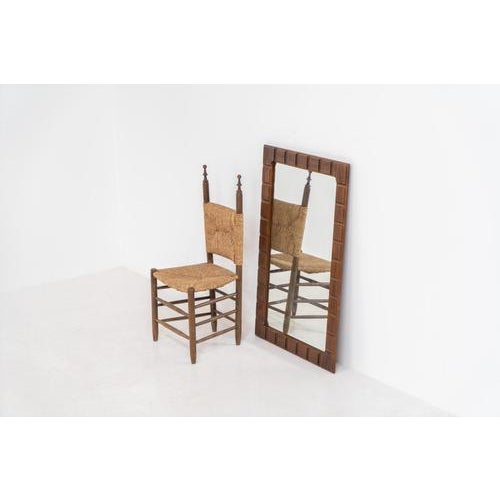 Sculptural graphic wall mirror (Sweden, 1960s). This wall mirror is made out of stained oak and offers a deeply carved...