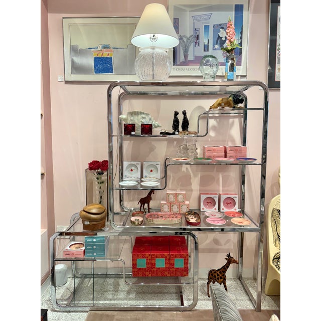 An exquisite chrome and glass etagere designed by the Design Institute of America, circa 1980's (unmarked). The top part...