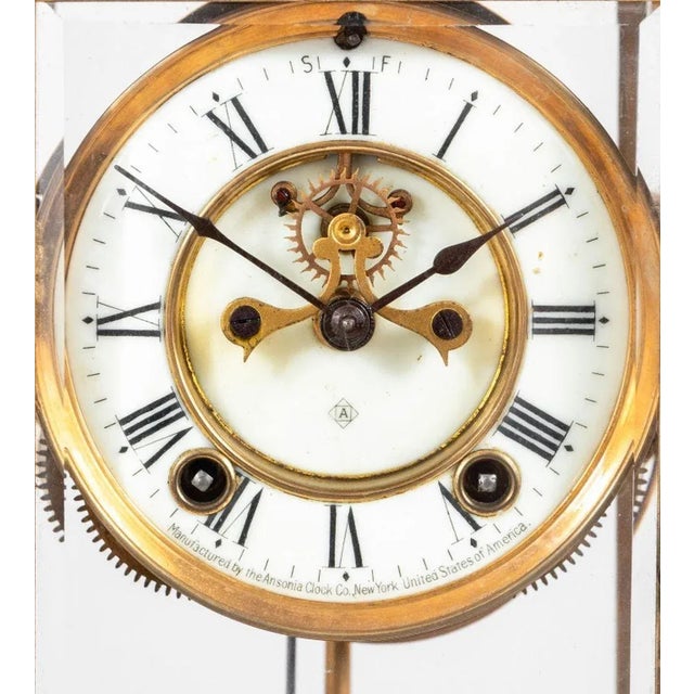 Ansonia Cast Brass Table Clock, late 19th century, the elaborate case with glaze panels enclosing a circular enamel dial...