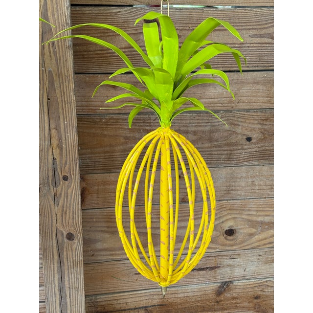 Add a punch of playful tropical flair with this vibrant pair of vintage tole metal hanging pineapple sculptures. Hand-...