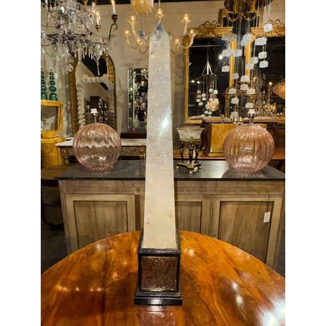 The product is a large 19th-century French rock crystal and boulle obelisk. This unique and collectible piece showcases...