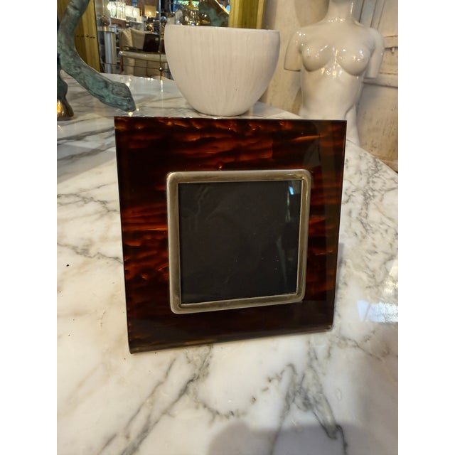 An elegant Italian photo frame crafted in richly mottled tortoiseshell Lucite, dating to the 1970s. The frame features a...