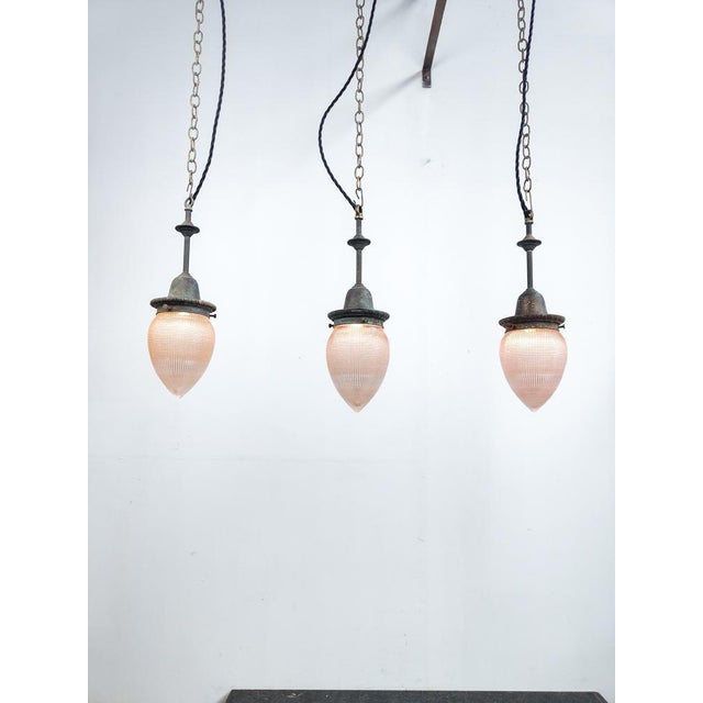 : Beautiful early English Holophane acorn pendant lights, constructed out of pressed glass with verdigris brass fixtures...