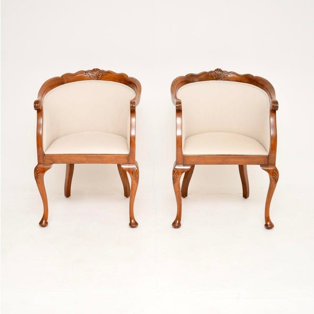 A beautiful pair of antique Queen Anne style walnut tub armchairs. They were made in England and date from around the...