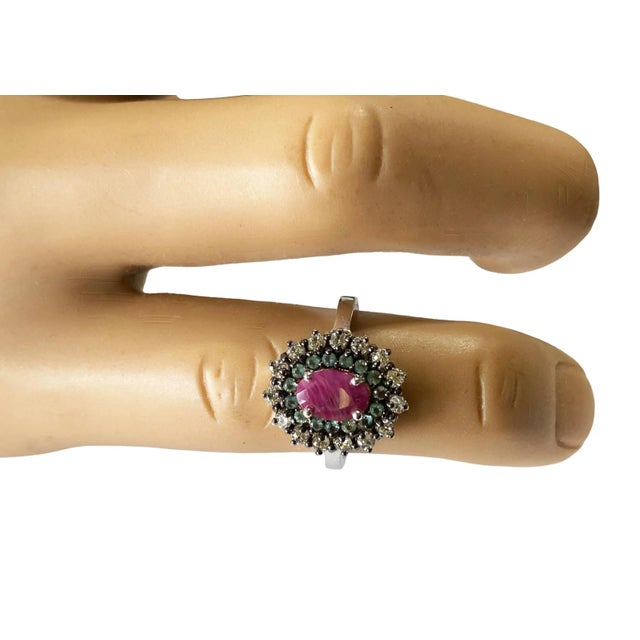 This elegant sterling silver ring size 5 is embellished with an oval Ruby and semi-precious round stones Aquamarine, along...