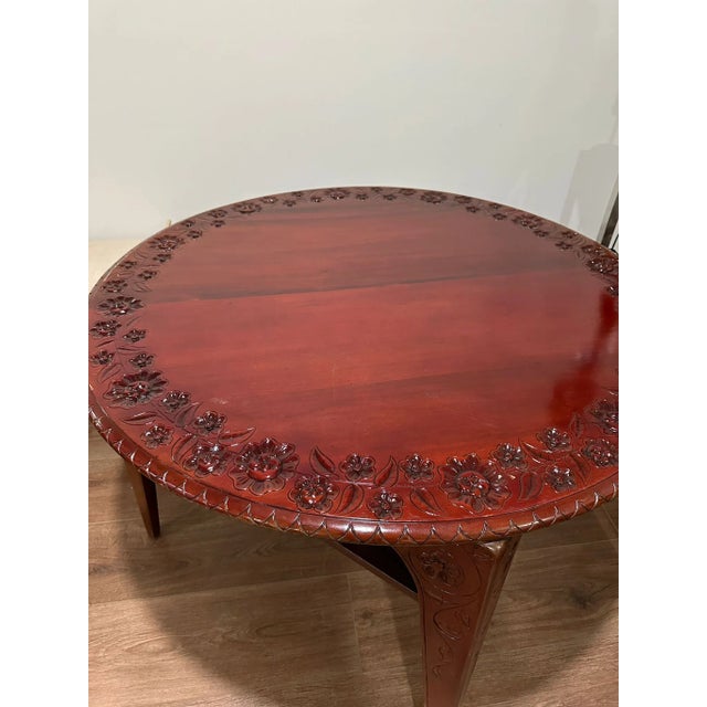 An interesting round table could be used for puzzles, games, or dining. Pretty detailing of flowers carved into the solid...
