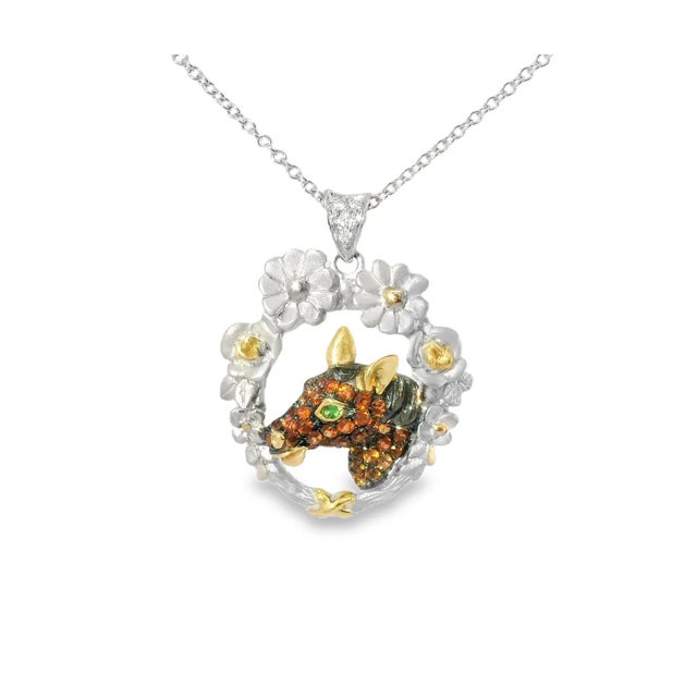 Elegant white gold horse pendant featuring vibrant orange sapphires, sparkling diamonds, and a single emerald eye. A...