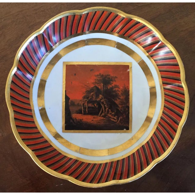 An early Derby scallop shaped deep dish with orange and black banding enhanced with gilding. A central reserve painting...