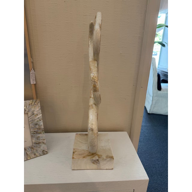 Inspired by snake like forms, this sculptural object crafted of Kabibe Shell sits on a square base and adds height and...