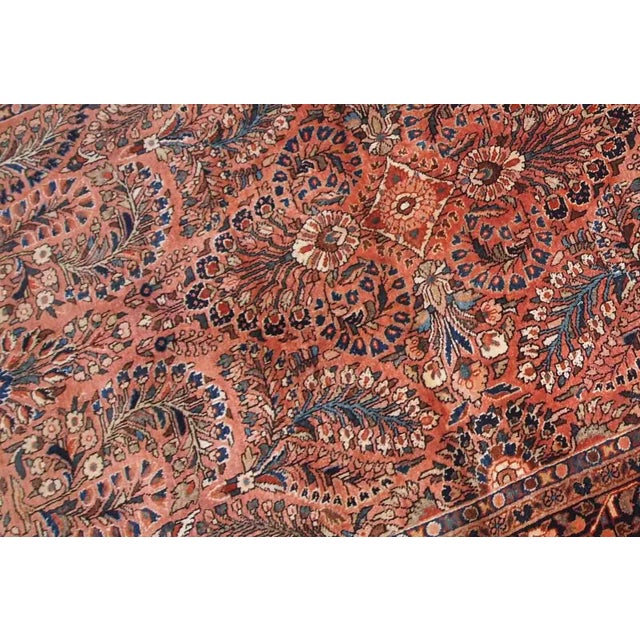 Handmade antique Persian Sarouk rug in original good condition. The rug is from the beginning of 20th century made in red...