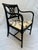 A single vintage neoclassical style wood armchair featuring tall curved arms and a pierced lattice style back with...