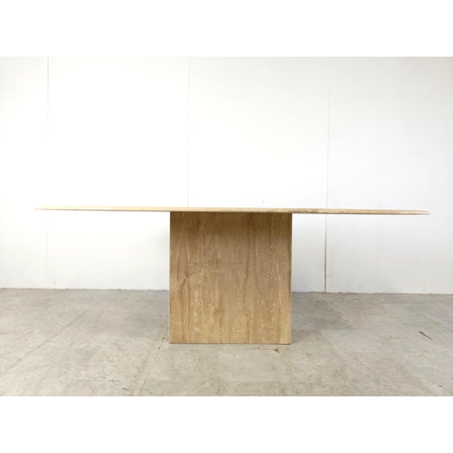 Elegant travertine dining table with a beautiful naturally veined table top with a beveled edge. Timeless piece. Sits up...