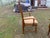 The product is a set of two vintage walnut/cane back dining armchairs, featuring a medium brown wood and pale yellow...