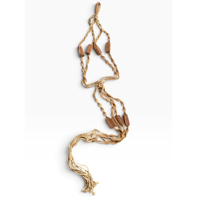 Extra-long vintage macramé hanging plant holder in a warm natural tan tone, featuring intricate knotted detailing, braided...