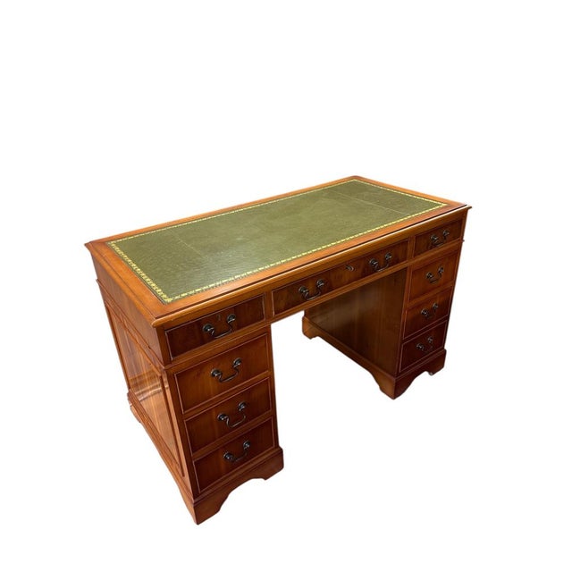 Classic English-style pedestal desk with green leather inset and multiple drawers. Timeless design, ideal for home office...